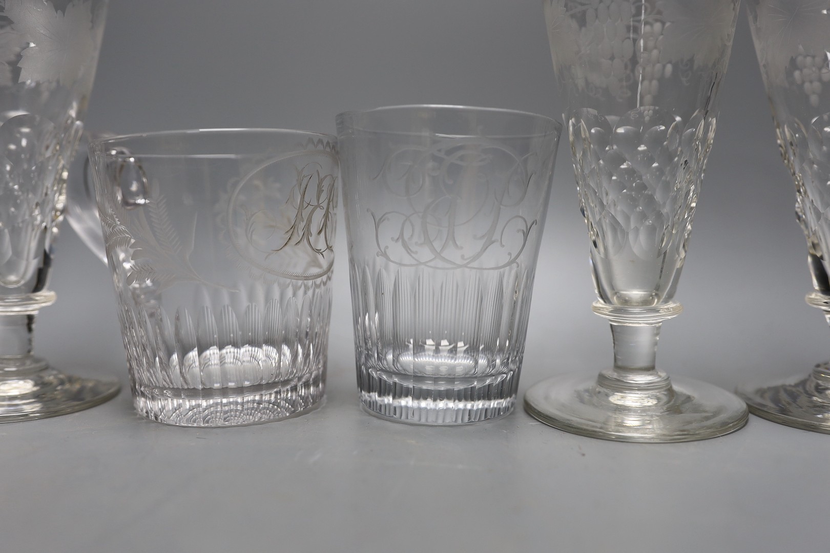 A set of four etched glass flutes, a similar tumbler with an aristocratic crest and mug, and, Flutes 25cms high.